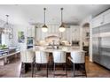 Bright kitchen featuring a large island with marble countertop, pendant lights, and stainless steel appliances at 455 Forest St, Denver, CO 80220