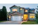 Inviting two-story home with a stone-accented facade, a manicured lawn, and a brick-paved driveway at 6266 Holman St, Arvada, CO 80004