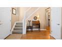 Inviting foyer featuring hardwood floors, staircase, and classic decorative elements at 8403 S Miller Ct, Littleton, CO 80127