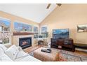 Cozy living room featuring a fireplace, large windows, and comfortable seating at 8403 S Miller Ct, Littleton, CO 80127