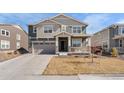 Two-story home featuring a covered front porch, a two-car garage, and neutral-tone siding at 14800 Hudson St, Thornton, CO 80602