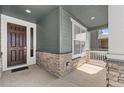 Inviting covered front porch detailed with stone accents and a stylish entrance door at 14800 Hudson St, Thornton, CO 80602