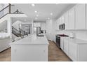 Bright kitchen boasts stainless appliances, white cabinets, and a large center island at 14800 Hudson St, Thornton, CO 80602