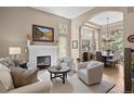 Bright living room with a fireplace, comfortable seating, and seamless flow to the formal dining area at 3315 Klondike Pl, Castle Rock, CO 80108