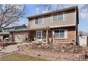 Charming two-story home with a well-manicured front yard, walkway and brick-and-siding facade at 13957 E Louisiana Pl, Aurora, CO 80012