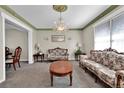 Formal living room with ornate chandelier, decorative moldings, and vintage furnishings at 13957 E Louisiana Pl, Aurora, CO 80012