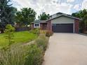 Beautiful two-story home with a brick facade, lovely landscaping, and a two car garage at 5971 Windy St, Golden, CO 80403