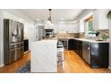Modern kitchen with stainless steel appliances, white cabinets, and center island with seating at 8288 W Chestnut Ave, Littleton, CO 80128