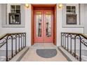 Close up of the red, glass-paneled front door with black iron railing at 215 E 11Th Ave # C3, Denver, CO 80203