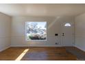 Inviting living room featuring hardwood floors, a front door, and a large window at 10454 Grant Dr, Northglenn, CO 80233