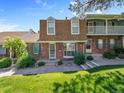 Brick townhome with manicured lawn and garden beds, offering classic curb appeal on a sunny day at 7391 S Knolls Way, Centennial, CO 80122