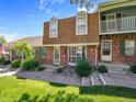 Inviting brick townhome with tidy landscaping, showcasing a cozy, well-maintained facade and lawn at 7391 S Knolls Way, Centennial, CO 80122