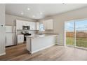 Modern kitchen featuring white cabinetry, stainless steel appliances, and an island, perfect for cooking and entertaining at 48275 Shetland Dr, Bennett, CO 80102