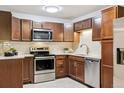 Updated kitchen features wood cabinets, stainless appliances, tile backsplash, and granite counters at 650 S Alton Way # 10A, Denver, CO 80247