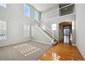 Two-story living room with hardwood floors, high ceilings, and staircase at 3587 Vestal Loop, Broomfield, CO 80023