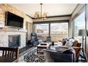 Open concept living room with stone fireplace, area rug, mountain views and comfortable furniture at 1275 Washington Ave, Golden, CO 80401