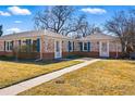 Quaint home with brick exterior, blue shutters, and a well-manicured lawn, offering great curb appeal at 1257 Locust St, Denver, CO 80220