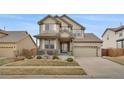 Charming two-story home featuring a well-manicured front yard, covered porch, and a two-car garage at 13475 Spruce St, Thornton, CO 80602