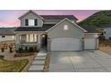 Charming two-story home with a three car garage and landscaped front yard nestled against a picturesque hillside at 5446 Mesa Top Dr, Monument, CO 80132