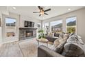 Bright living room with a stone fireplace, large windows with mountain views, and a comfortable gray sofa at 5446 Mesa Top Dr, Monument, CO 80132