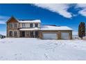 Charming two-story home with a two-car garage nestled in a snow-covered landscape at 10650 Yellowstone Rd, Longmont, CO 80504