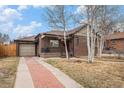 Brick home with attached garage and cozy front porch and well-maintained landscaping at 1363 Stuart St, Denver, CO 80204