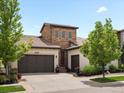 Charming stucco two-story home with a tiled roof, stone accents, mature landscaping, and a two-car garage at 15264 W La Salle Ave, Lakewood, CO 80228