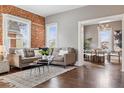 Relaxing living room features a brick wall, comfortable seating, and hardwood floors at 321 S Emerson St, Denver, CO 80209
