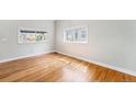 Bright, spacious bedroom with pristine hardwood floors and natural light from two large windows at 3921 S Acoma St, Englewood, CO 80110
