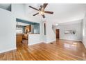 Sun-drenched living room featuring beautiful hardwood floors, neutral walls, and stylish ceiling fan at 3921 S Acoma St, Englewood, CO 80110