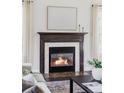 Close-up of cozy fireplace with wood mantel and decorative tile surround at 8739 E 23Rd Ave, Denver, CO 80238