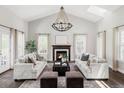 Bright living room with vaulted ceilings, fireplace, and elegant chandelier at 8739 E 23Rd Ave, Denver, CO 80238