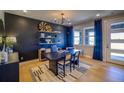Stylish living room with dark accent wall, contemporary decor, and hardwood floors at 8795 Hugo Dr, Littleton, CO 80125