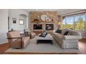 Cozy living room with a stone fireplace, wooden floors and comfortable seating at 4336 Chateau Ridge Rd, Castle Rock, CO 80108