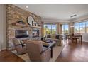 Inviting living room featuring a stone fireplace, hardwood floors and view at 4336 Chateau Ridge Rd, Castle Rock, CO 80108