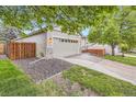 Traditional home showcasing an attached two-car garage, manicured lawn, and inviting front porch at 16179 W 70Th Pl, Arvada, CO 80007