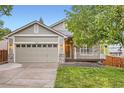 Traditional home showcasing an attached two-car garage, manicured lawn, and inviting front porch at 16179 W 70Th Pl, Arvada, CO 80007