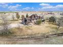 Aerial view of a home in a rural setting with a large yard and mature trees surrounded by pasture land at 28800 E 168Th Ave, Brighton, CO 80603