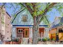 Charming two-story home with brick stairs, pillars, wooden front door, and a large tree in the front yard at 729 E 10Th Ave, Denver, CO 80203