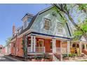 A two-story home boasting a blend of brick and light blue wood, featuring a cozy front porch with decorative pillars at 729 E 10Th Ave, Denver, CO 80203