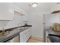 Functional kitchen features clean white cabinets, stainless steel appliances and wood-look floors at 9100 E Girard Ave # 7, Denver, CO 80231