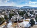 Aerial view of a two-story home in a neighborhood with mountain views in the distance at 8 Mountain Willow Dr, Littleton, CO 80127