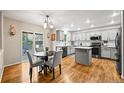 Bright kitchen featuring light gray cabinets, a center island, and wood flooring at 2667 E 132Nd Ave, Thornton, CO 80241