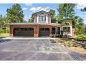 A beautiful home with a brick two-car garage and paved driveway surrounded by mature trees at 1240 Lone Scout Lookout, Monument, CO 80132