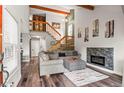 Spacious living room featuring modern fireplace, wooden stairs, and neutral decor at 943 S Fairplay St, Aurora, CO 80012
