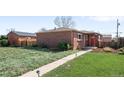Quaint brick home with a well-maintained lawn and charming landscaping at 3316 N Glencoe St, Denver, CO 80207