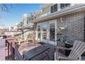 View of the back porch with seating, access to the house through glass doors, and a brick facade at 5252 W 68Th Ave, Arvada, CO 80003