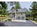 Inviting two-story gray home with an attached two-car garage, complemented by beautiful landscaping and a charming deck at 7312 Marshall Rd, Larkspur, CO 80118