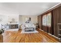Bright living room boasts a fireplace, hardwood floors, and comfortable seating area at 3871 W Saratoga Ave, Littleton, CO 80123