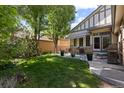 Backyard showcasing a well-manicured lawn, mature trees, patio area, and a cozy outdoor seating arrangement at 652 Ulster Way, Denver, CO 80230